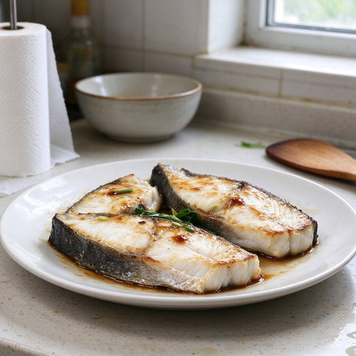 Thick white flatfish steaks with dark mottled skin on top, on a wooden board